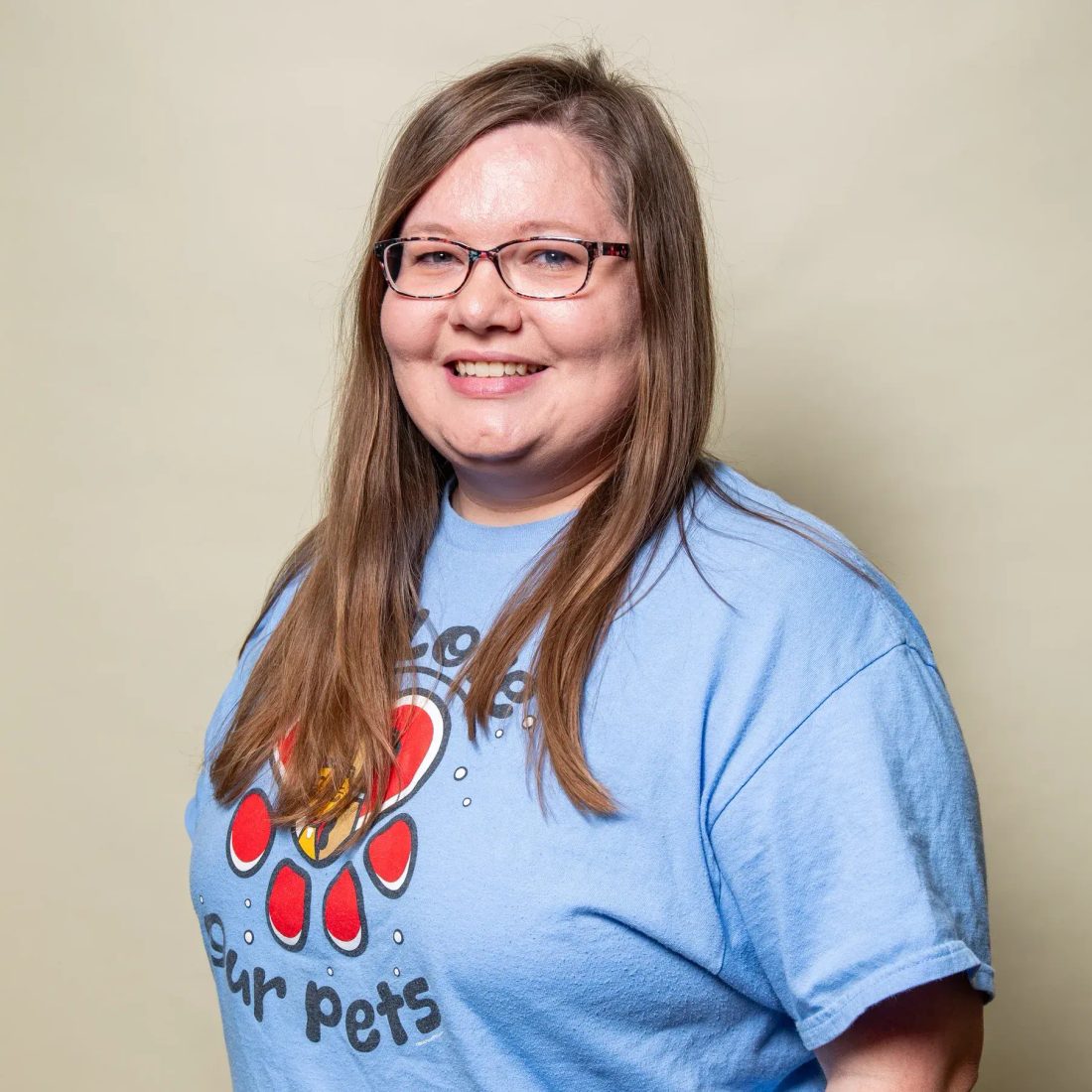 Woman with glasses in blue t-shirt with paw print design